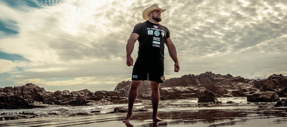 Travis Ortmayer on a rocky beach, competition gear