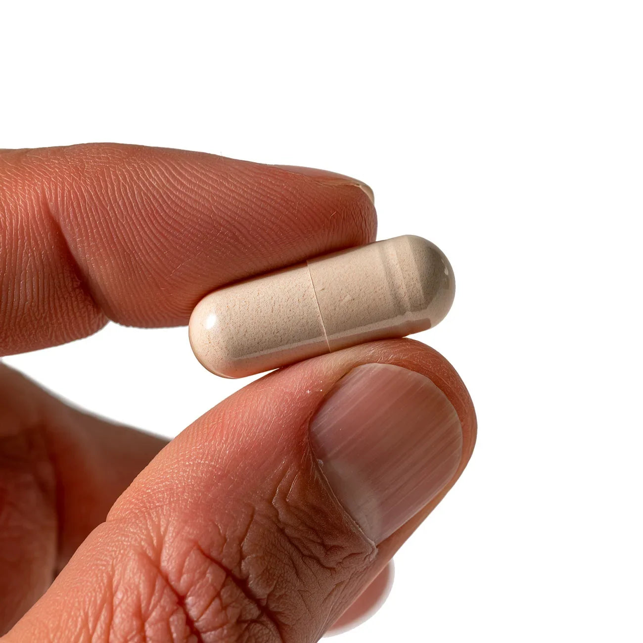 A Menerals capsule held between two fingers